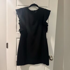 Little black dress with braiding on shoulders and ruffled sides. Size 6 petite.